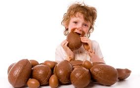Child stuffing face with Easter eggs